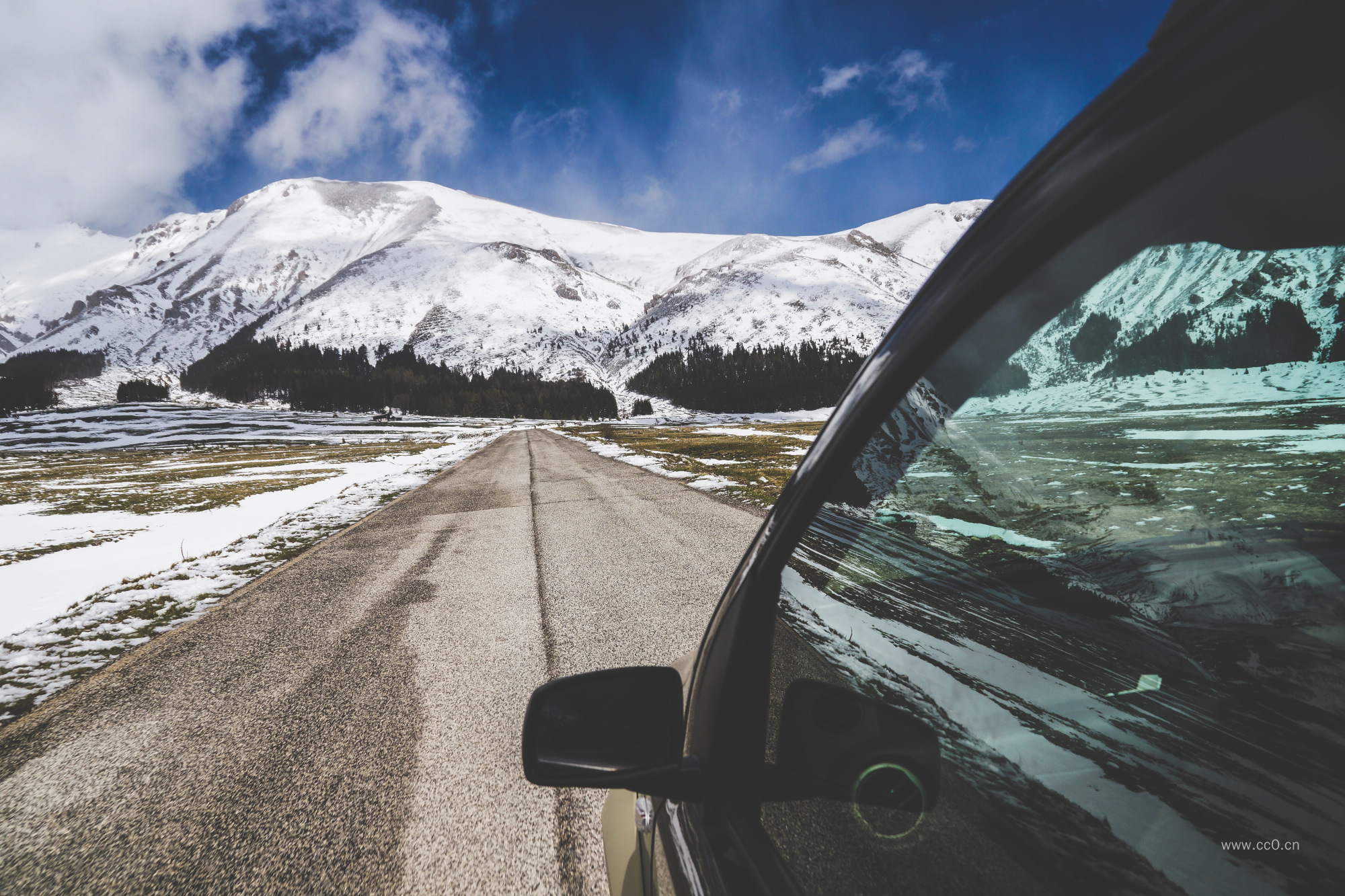 在公路上行驶的车辆与雪山图片