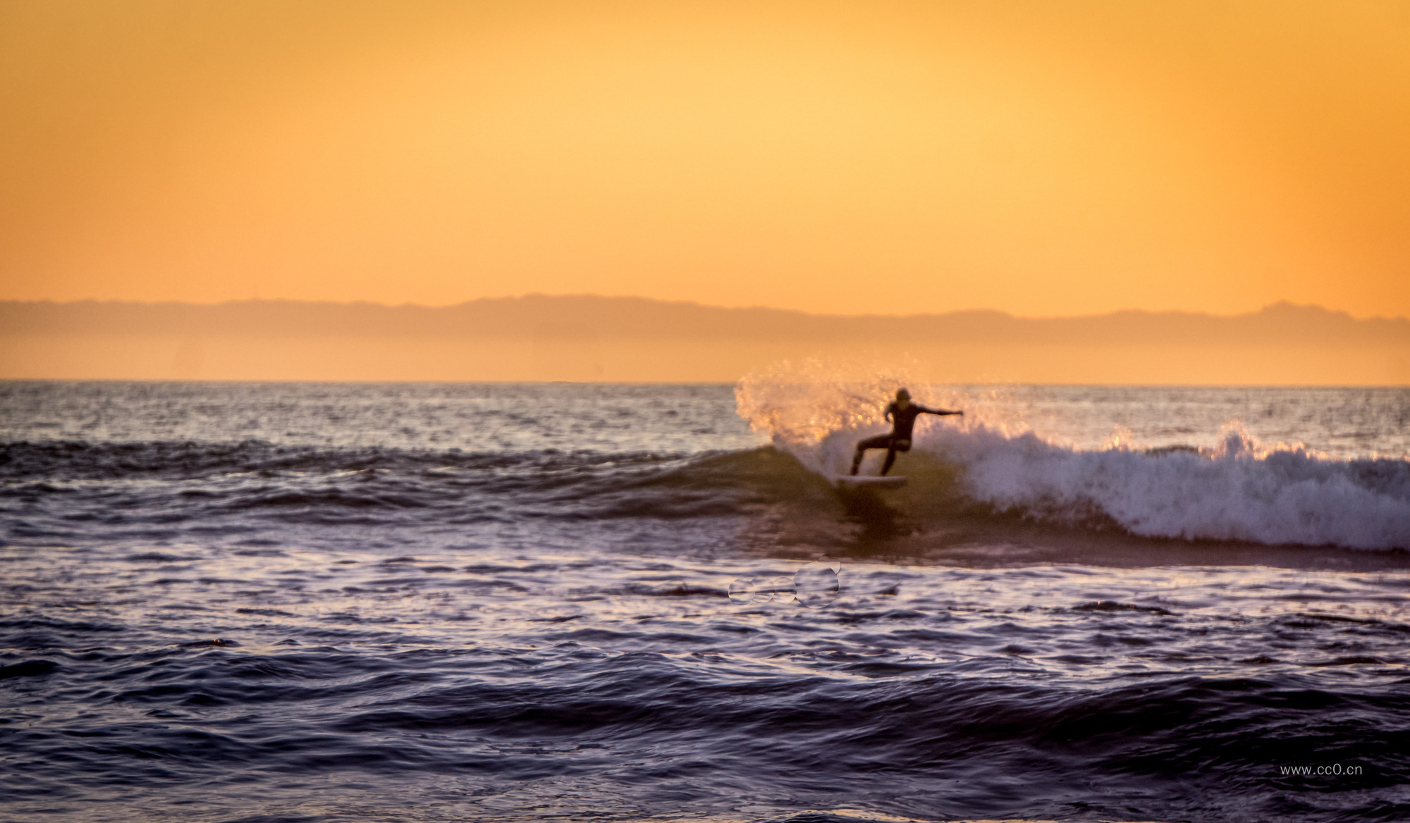 黄昏天空海面上冲浪的人