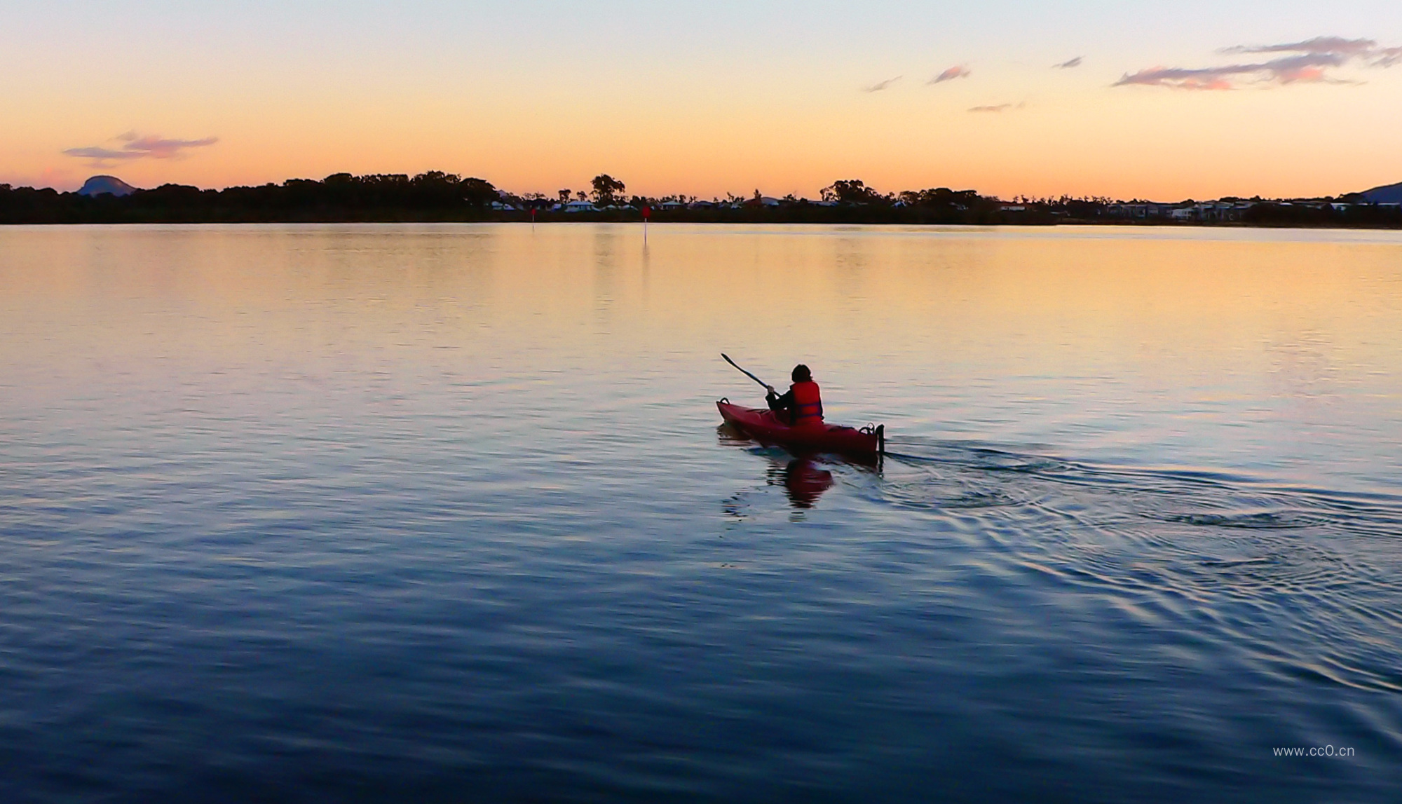 黄昏的湖面划皮艇的人