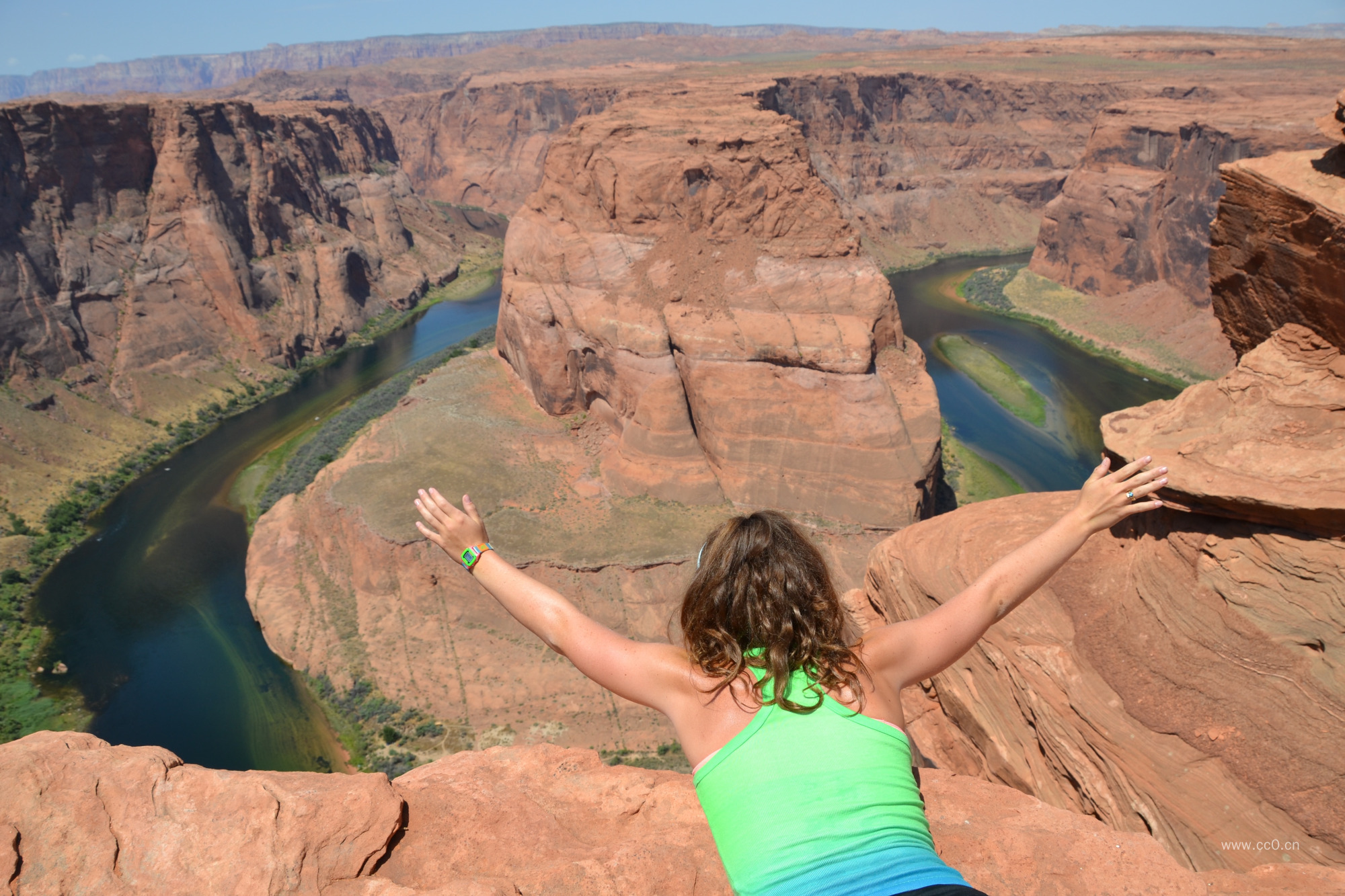 匍匐在马蹄湾峡谷悬崖上张开双臂的女性人物