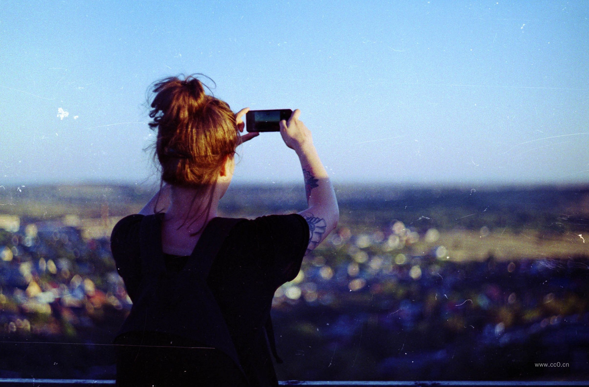 拿着手机拍摄的女人背影