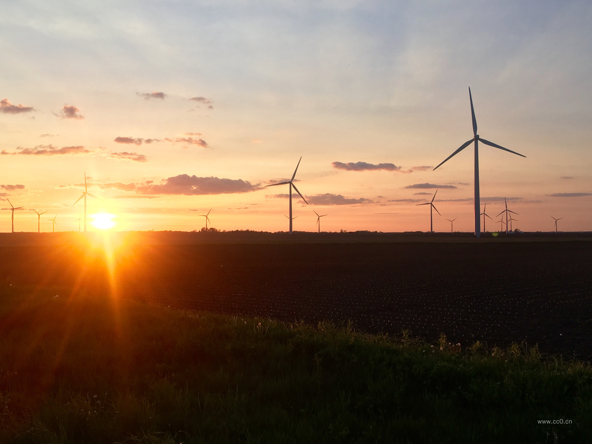 平原上的发电风车与日落太阳图片