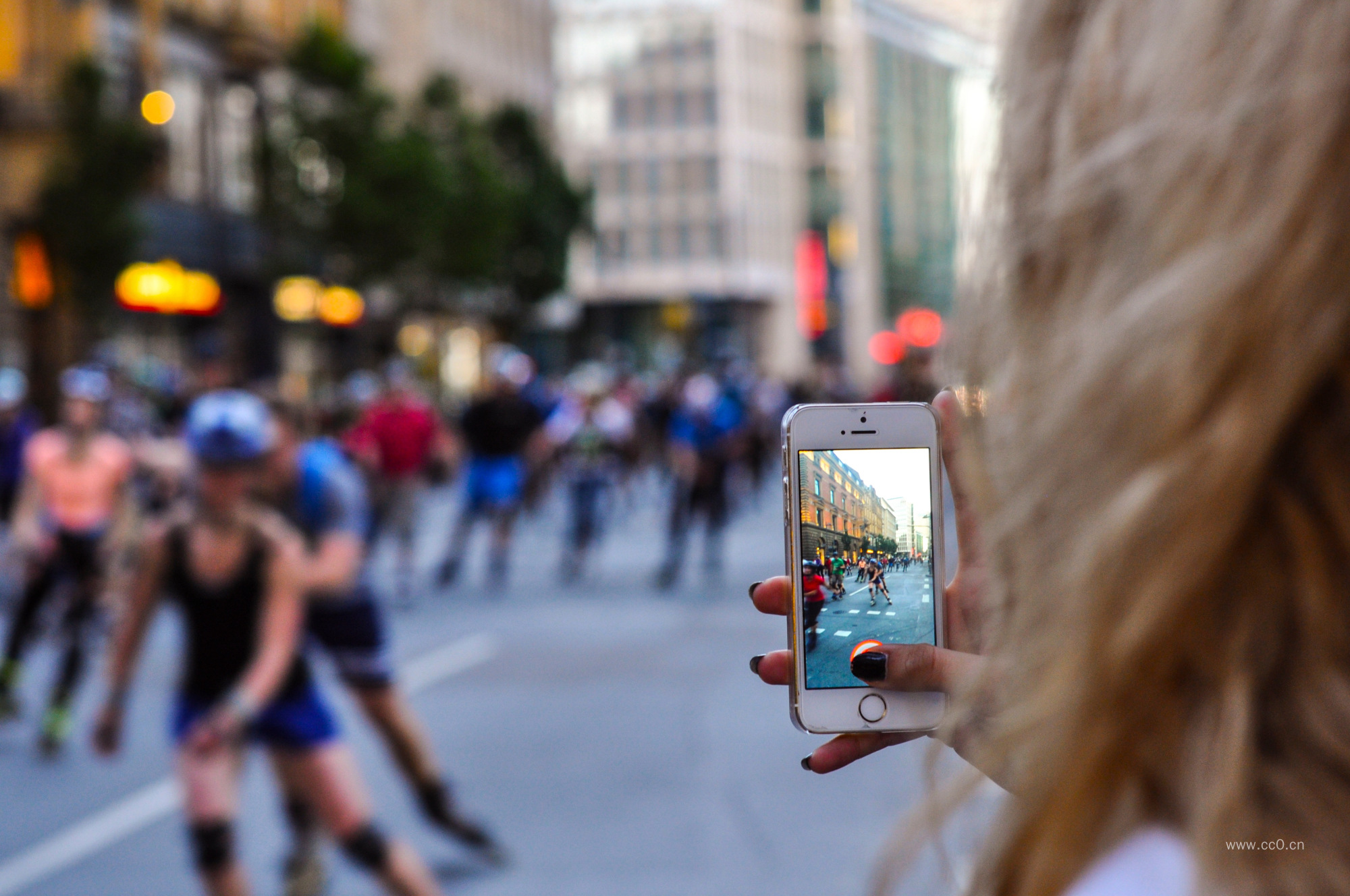 手拿手机在街道上拍摄的图片