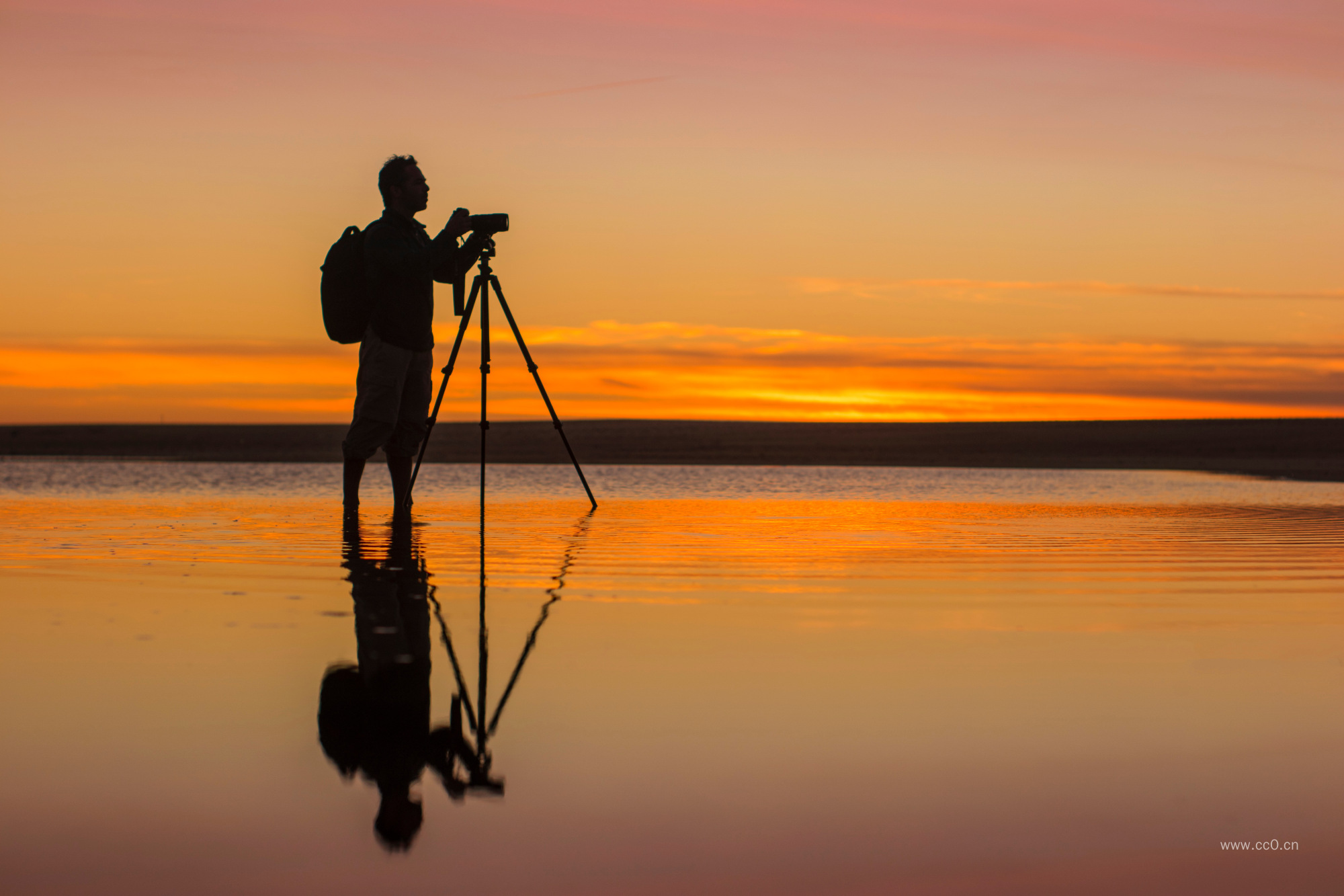 黄昏海滩上的摄影师人物剪影