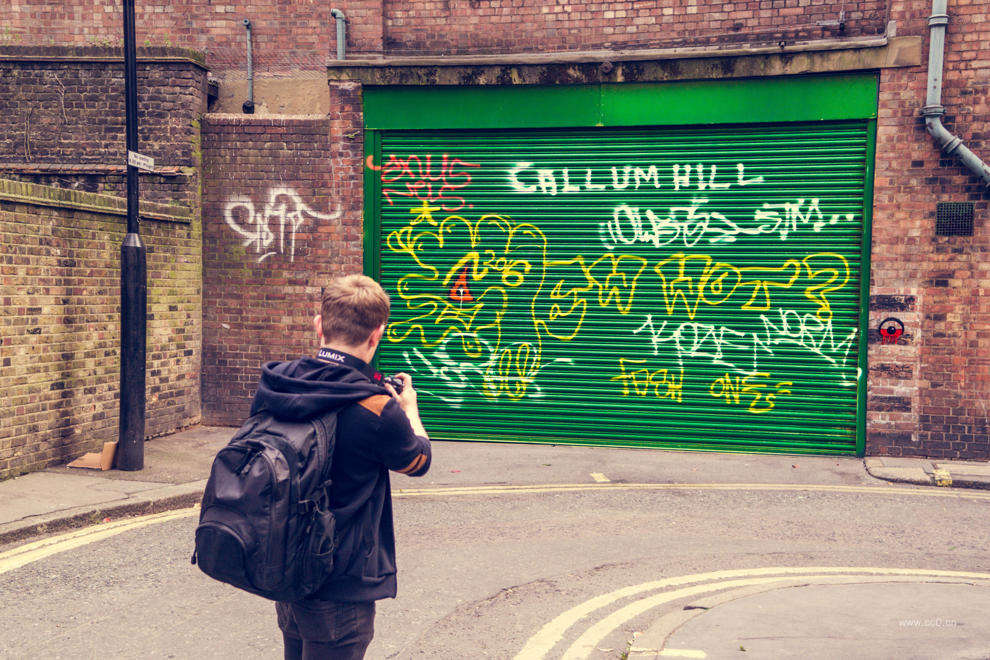 背包的人物背影与卷闸门上的涂鸦
