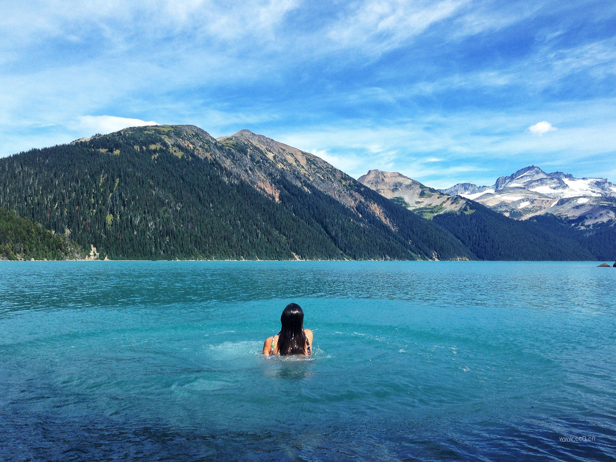 山与湖泊中游泳的女生背影