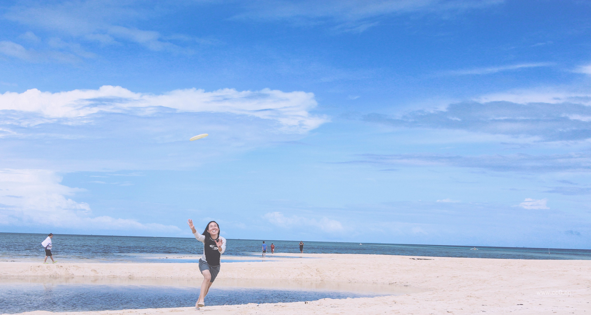 蓝天白云下海边奔跑的快乐女人