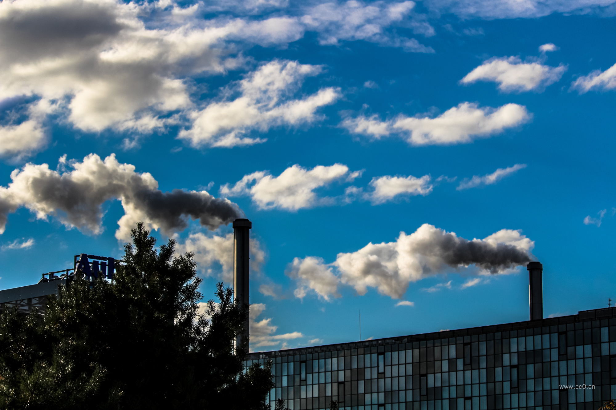 蓝天白云下的烟囱烟雾图片