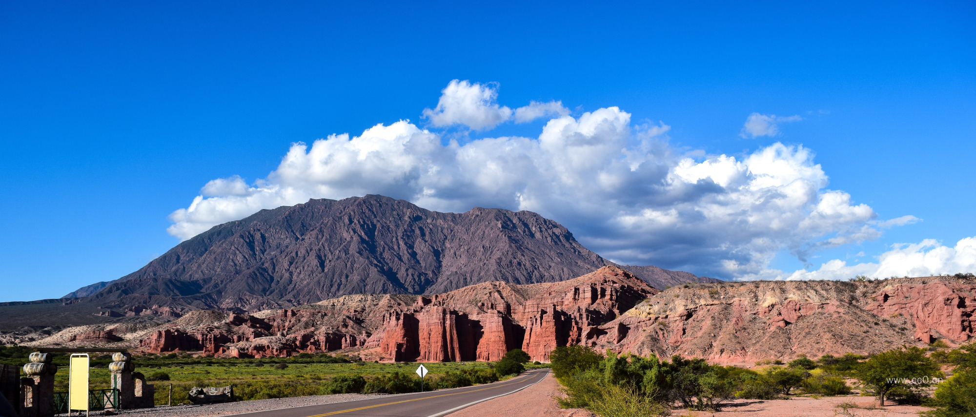 蓝天白云下荒漠中的山与公路