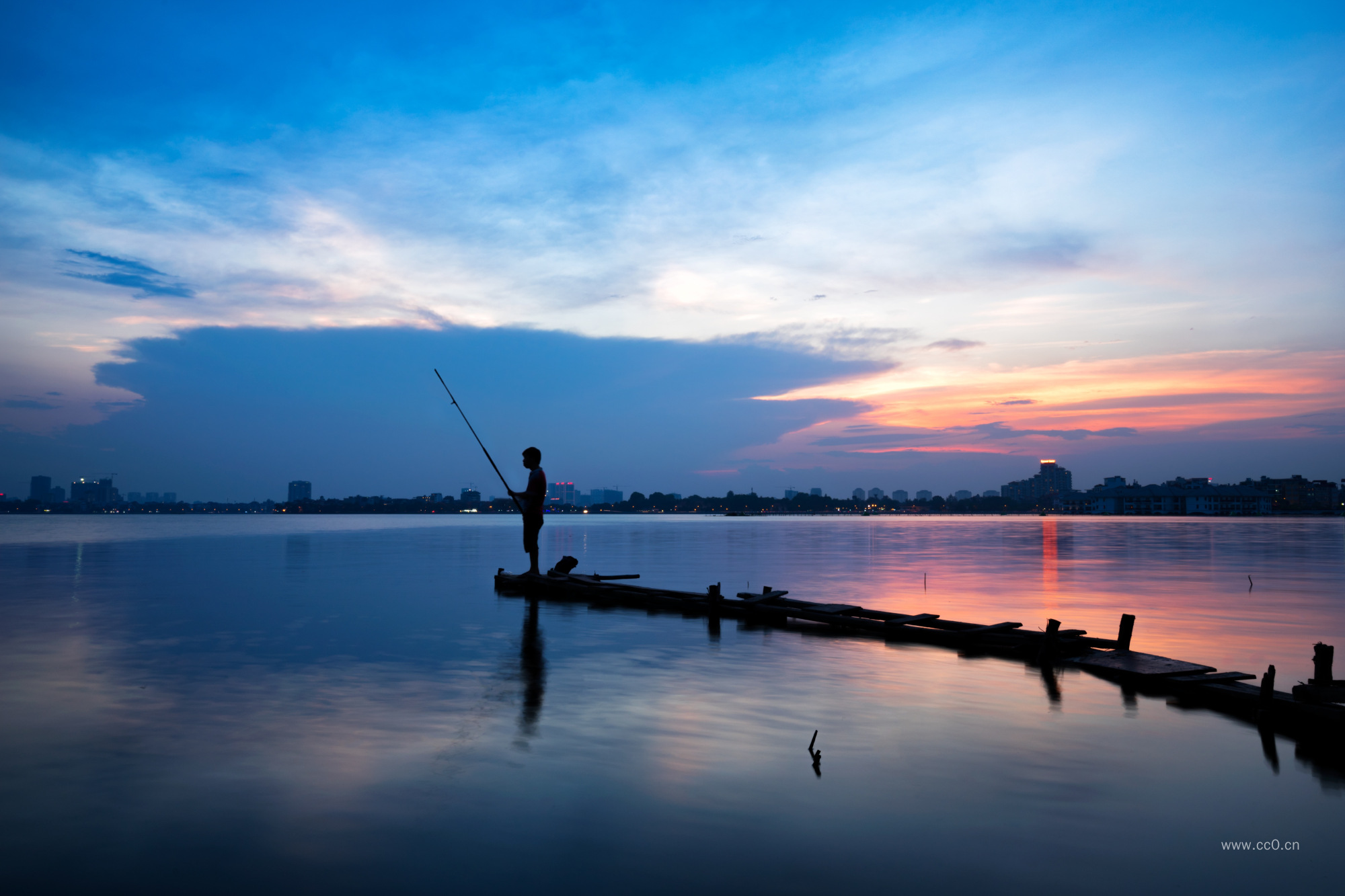 晚霞天空与湖泊钓鱼的人物剪影